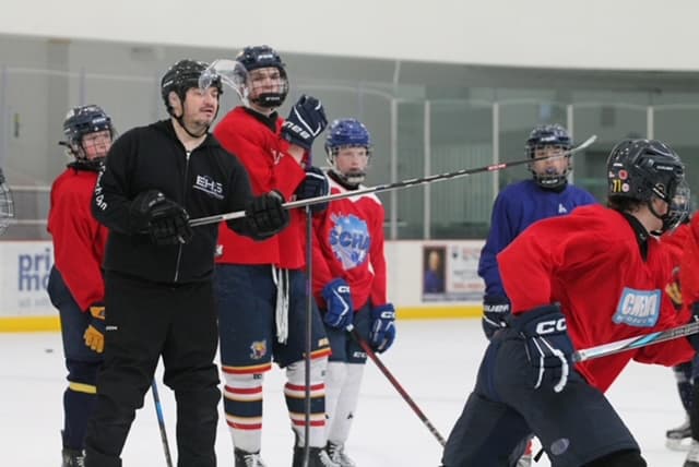 Coach Dan running an on-ice drill with players