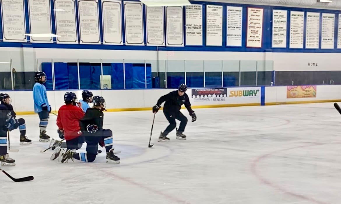 Coach Dan demonstrating a skating drill with the puck